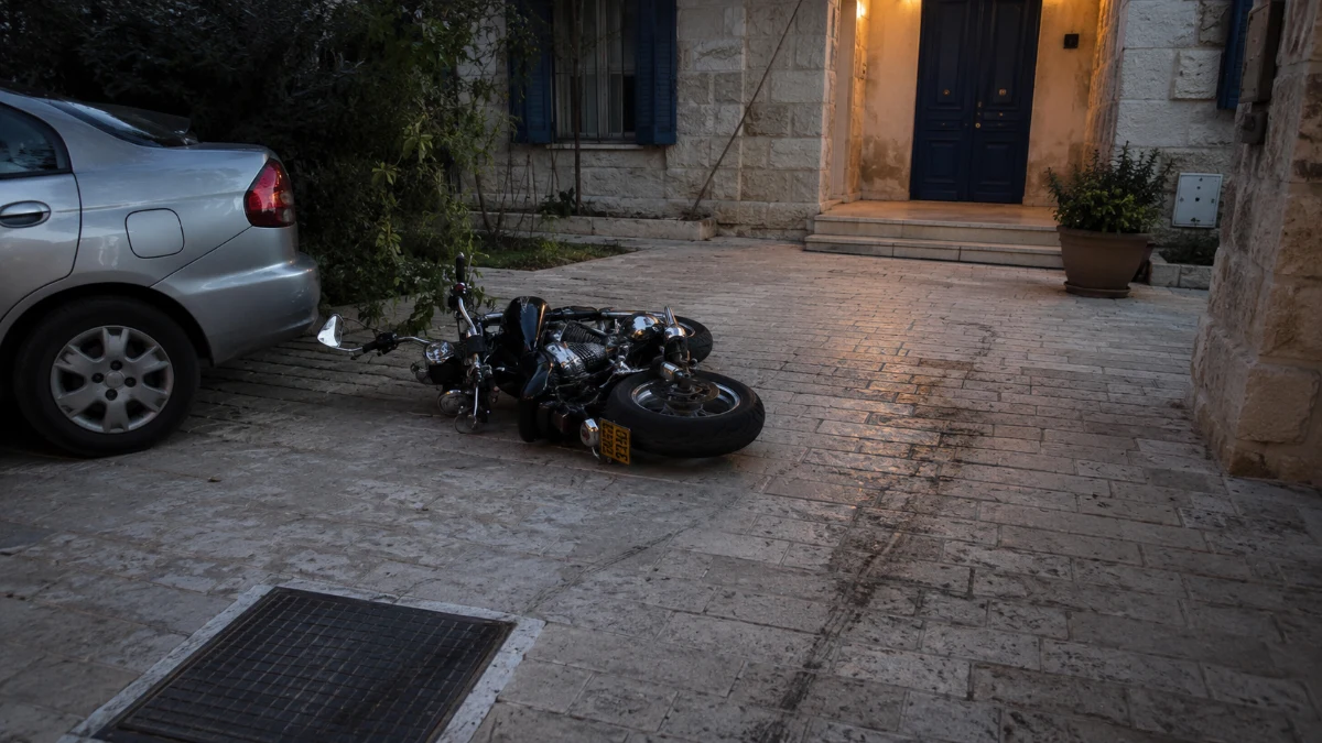 אופנוע כבד סמוך למכונית חונה ולפתח בית באזור העיר העתיקה בירושלים