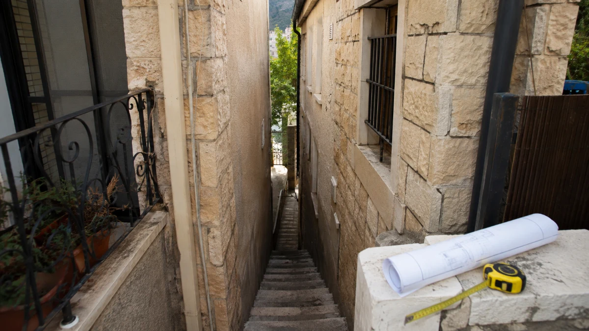 שביל צר בין שני בתים צמודי קרקע בצפת, המחולק לאורך גבול החלקות