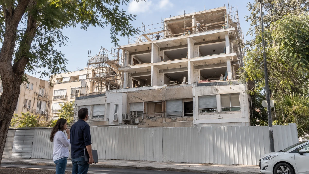 אתר בנייה של פרויקט תמ"א בתל אביב ולצדו בניין מגורים מאוכלס