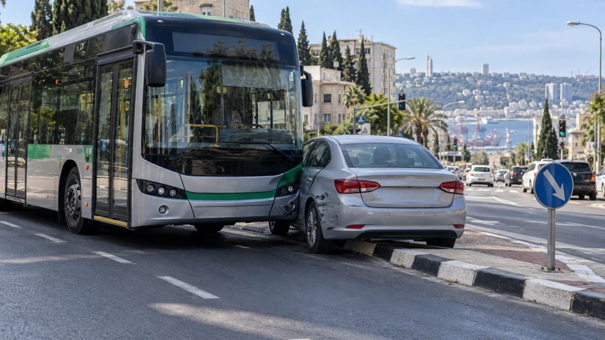 אוטובוס ציבורי לצד רכב פרטי על כביש עירוני דו-נתיבי, לאחר סטייה לעבר נתיב סמוך