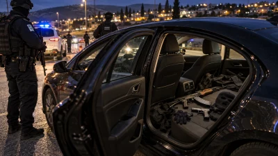 רכב כהה ליד מחסום משטרתי, ובתוכו ציוד הסוואה וכלי נשק שנתפסו לפני ירי