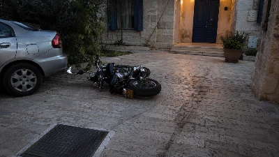 אופנוע כבד סמוך למכונית חונה ולפתח בית באזור העיר העתיקה בירושלים