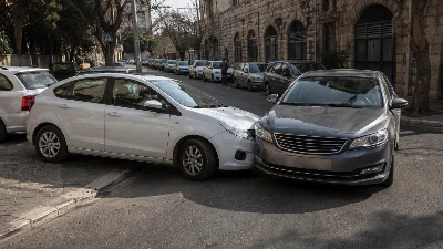 שתי מכוניות נוגעות זו בזו ליד מפרץ חניה בכביש ירושלמי צר