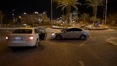 מונית עצורה בלילה במעגל תנועה עירוני באילת ורכב נוסף חוסם את דרכה, ללא אנשים נראים